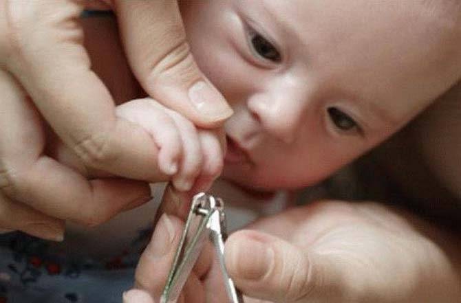 Как подстричь новорожденного. Стричь ногти ребенку. Стрижка ногтей новорожденному. Подстричь ногти новорожденному. Малышу стригут ногти.
