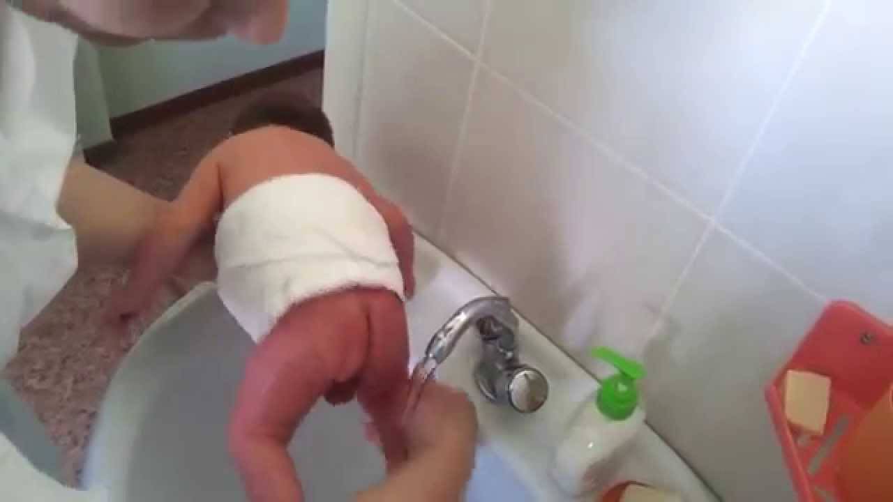 Как правильно подмываться после. Подмывание новорожденного. Подмывать новорожденного мальчика. Подмывание новорожденного под краном. Подмывание девочек новорожденных.